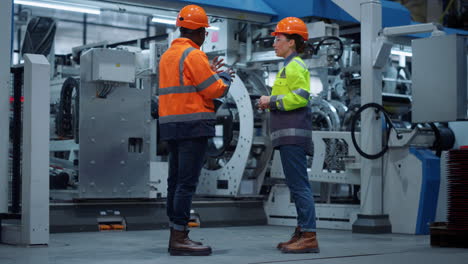 socios profesionales discutiendo el proyecto en una fábrica industrial moderna. trabajo en equipo