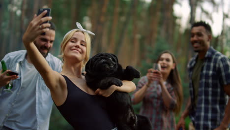 Smiling-people-having-fun-on-bbq-party-outside.-Man-jokingly-biting-dog-outdoors
