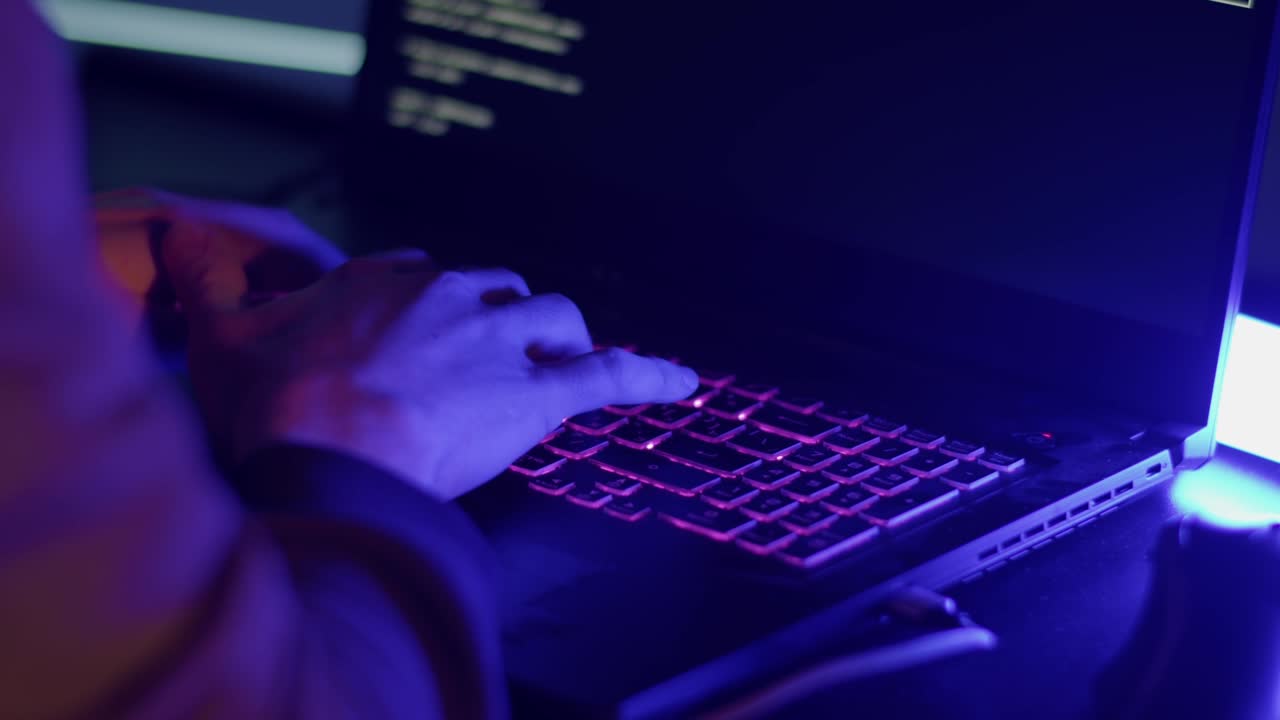 The hacker is typing fast on the keyboard due to the approach of the police