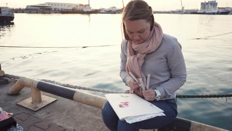 woman drawing watercolors at the harbor