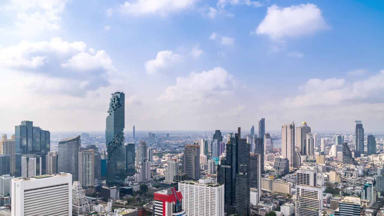 Bangkok business district city center above Silom area, with cloud pass over buildings and skyscrapers; panning right – Time Lapse