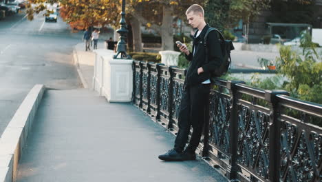 young student using mobile phone outdoors.