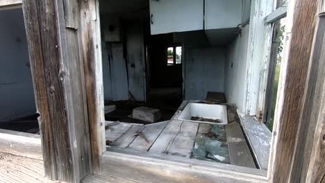 looking into a window in a old abandoned wooden house in the country