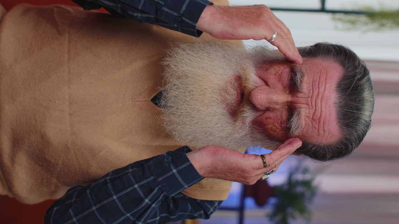 불만을 품은 고령 노인이 두통 문제를 치료하기 위해 사각지대를 마사지합니다. 편두통, 스트레스로 고통받고 있습니다.