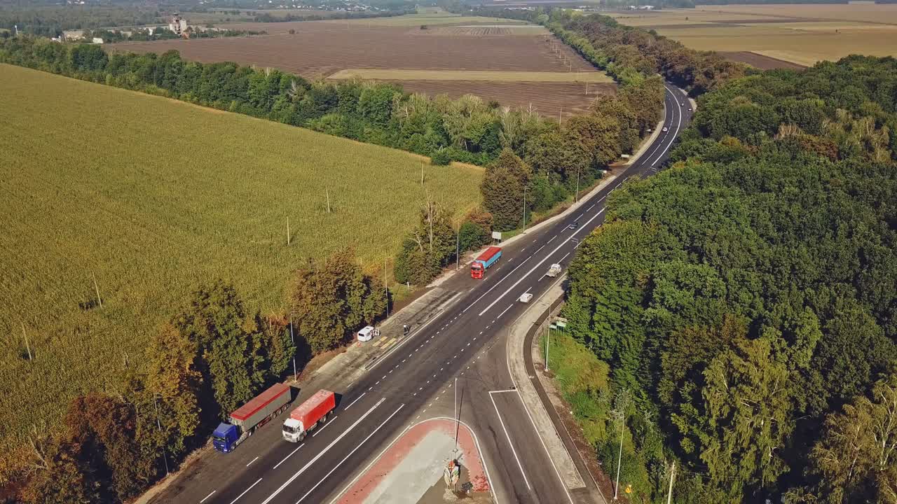 View of the long highway with the repair of a piece of road on the background of wonderful fields and trees around. Aerial landscape