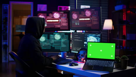 hacker che fa sabotaggio informatico usando ransomware trojan su laptop a schermo verde