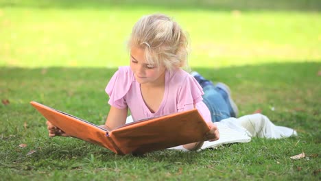 Young-girl-reading-a-book-outdoors