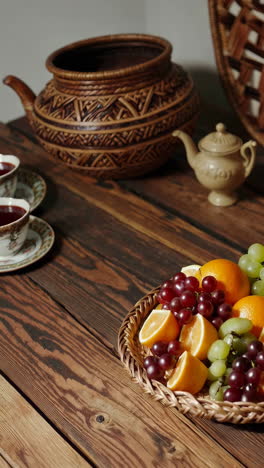 fruit platter on wooden table with decorative baskets and teapot