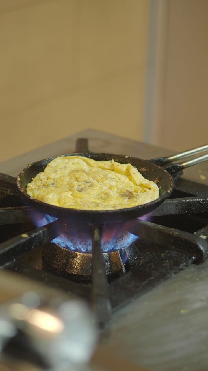 Chef Cooking Omelet in Frying Pan on Gas Stove