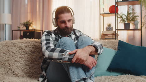 hombre triste en casa con auriculares canción de música melancólica estado de ánimo lloroso tranquilo corazón roto momento de divorcio