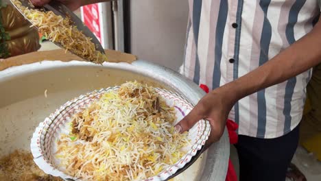kolkata style mutton biryani being served in a paper plate in a shop in kolkata.