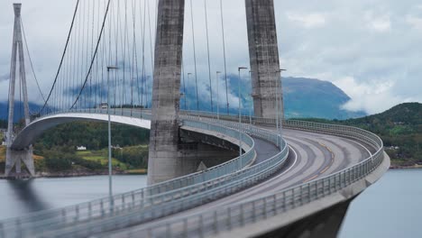 cars and trucks pass along the curves of the halogaand bridge above the fjord