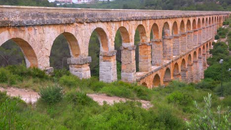 a beautiful roman aqueduct crosses a canyon in france