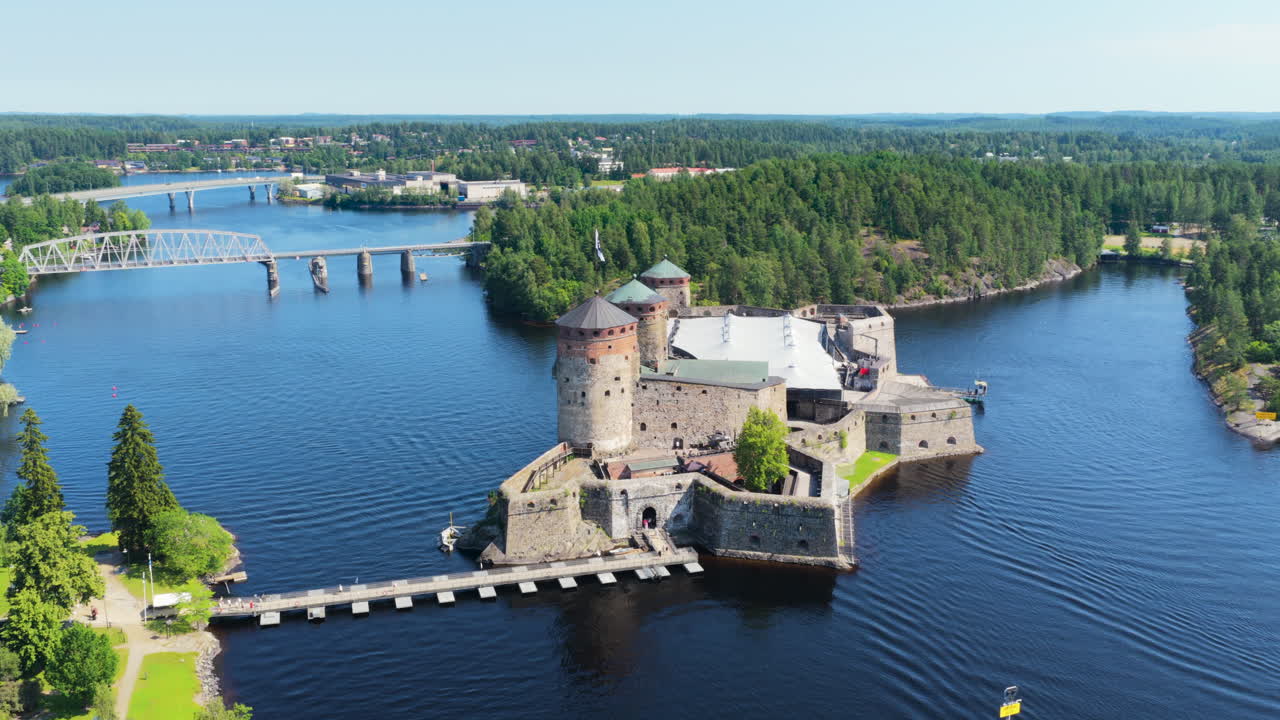Aerial view circling the Olavinlinna castle, sunny, summer day in Savo, Finland