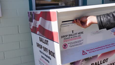 person voting at mail-in ballot drop box