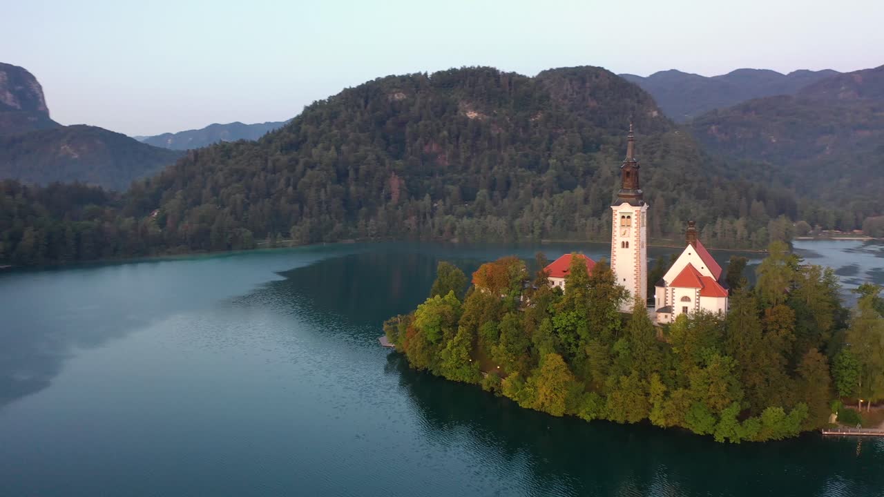 Lago di Bled, Slovenia - riprese aeree intorno alla Chiesa di Pellegrinaggio dell'Assunzione di Maria sopra il Lago di Bled in una splendida mattina d'estate, alba