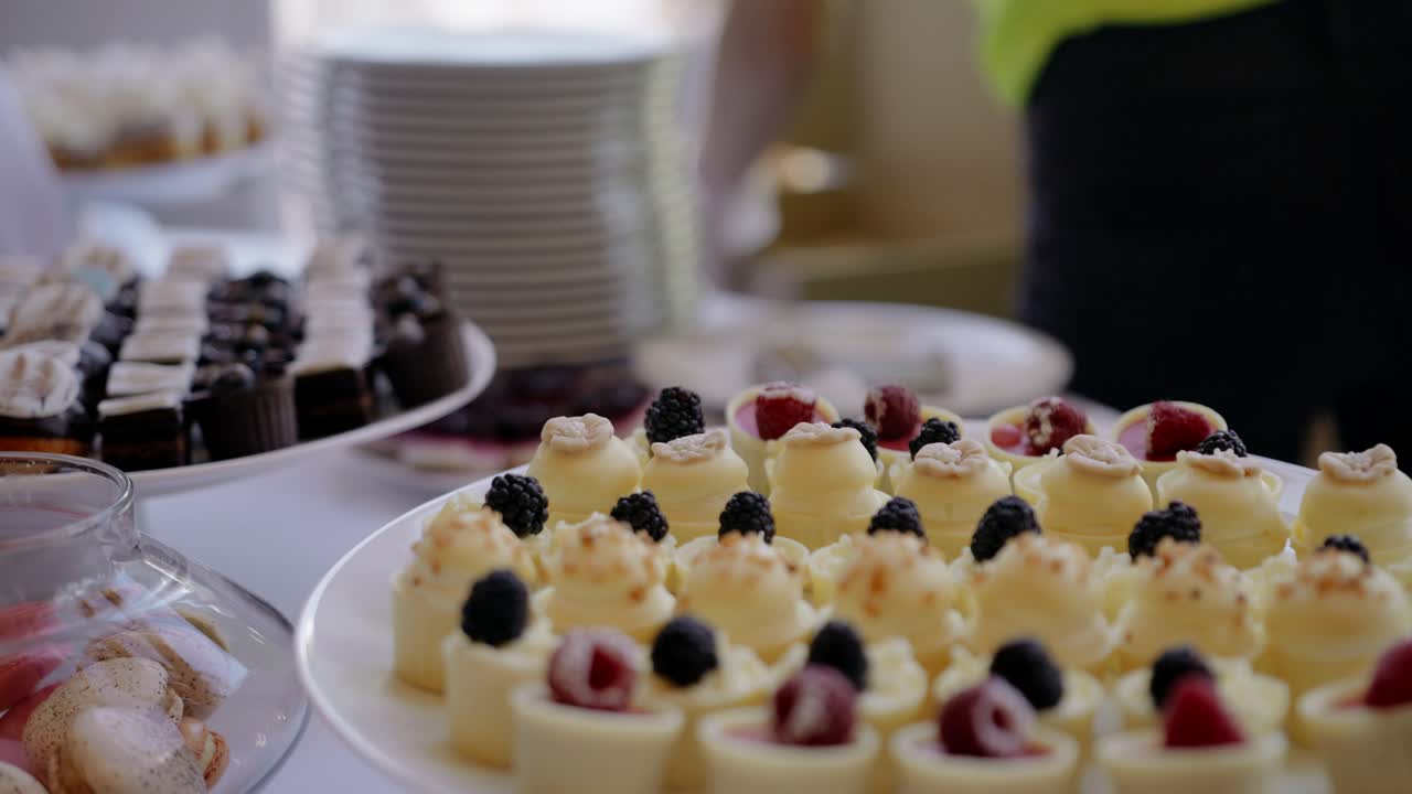 결혼식에서 디저트 뷔페 테이블에서 일하는 인식할 수 없는 케이터링 직원