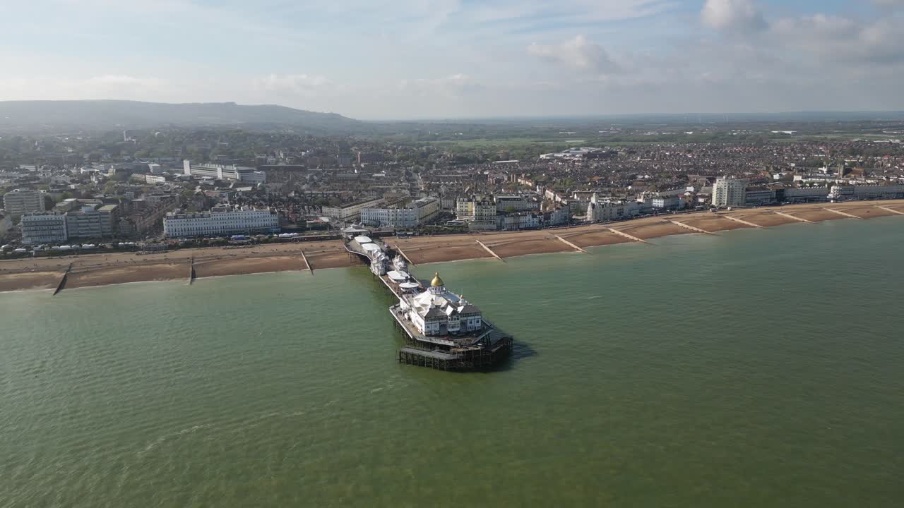 Flying around Eastbourne Pier, sea front and beach.Distant shot. Video shot with dji mini 3 pro drone in Eastbourne England. 4K video