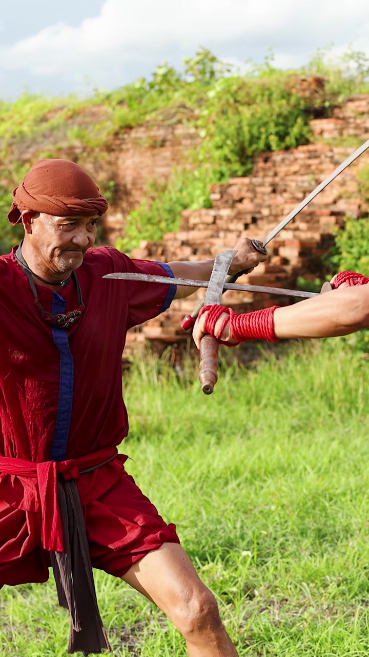 Due artisti marziali thailandesi che praticano il combattimento tradizionale con la spada