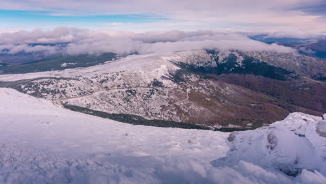 Timelapse-of-clouds-rolling-over-mountain-tops-during-winter