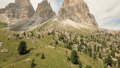 El-Dron-FPV-Se-Dirige-A-La-Montaña-Sasslong-De-Los-Dolomitas-Italianos,-Elevándose-Sobre-Formaciones-Rocosas-Y-Un-Antiguo-Teleférico-En-Su-Ascenso.