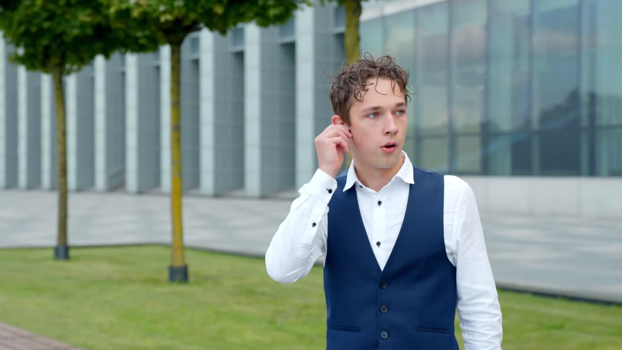 Dissapointed Businessman Walking While Talking On Call With Wireless Earbuds. - medium shot