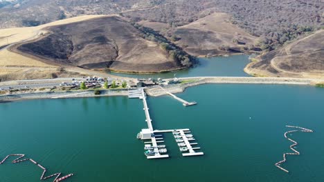 areal drone footage scanning lakeside docks and roads with california hills in the background