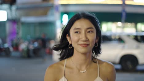 smiling asian woman in city at night