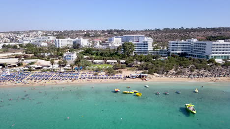aerial view of a holiday resort sandy beach, with beach umbrellas and sun beds