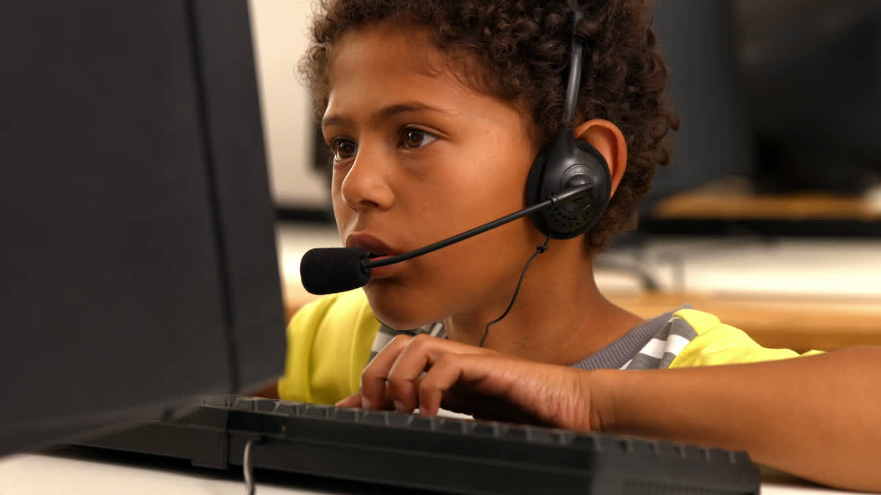 Cute pupil using computer in school
