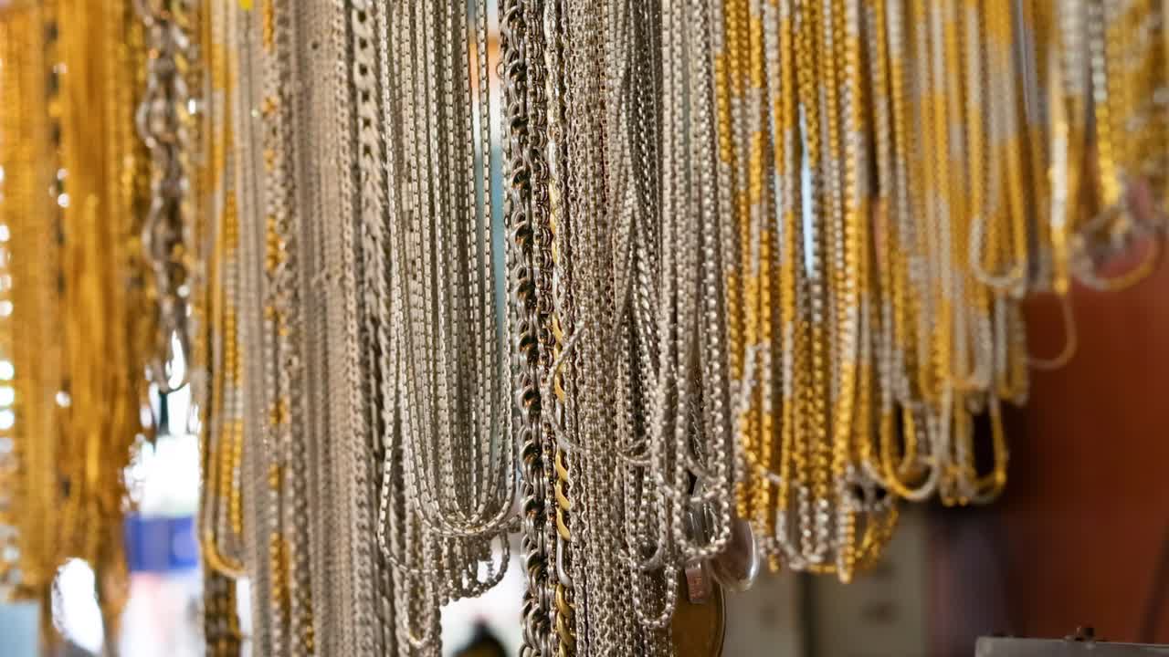 Colorful necklaces hang in a bustling market stall, capturing the lively atmosphere of a Phuket marketplace
