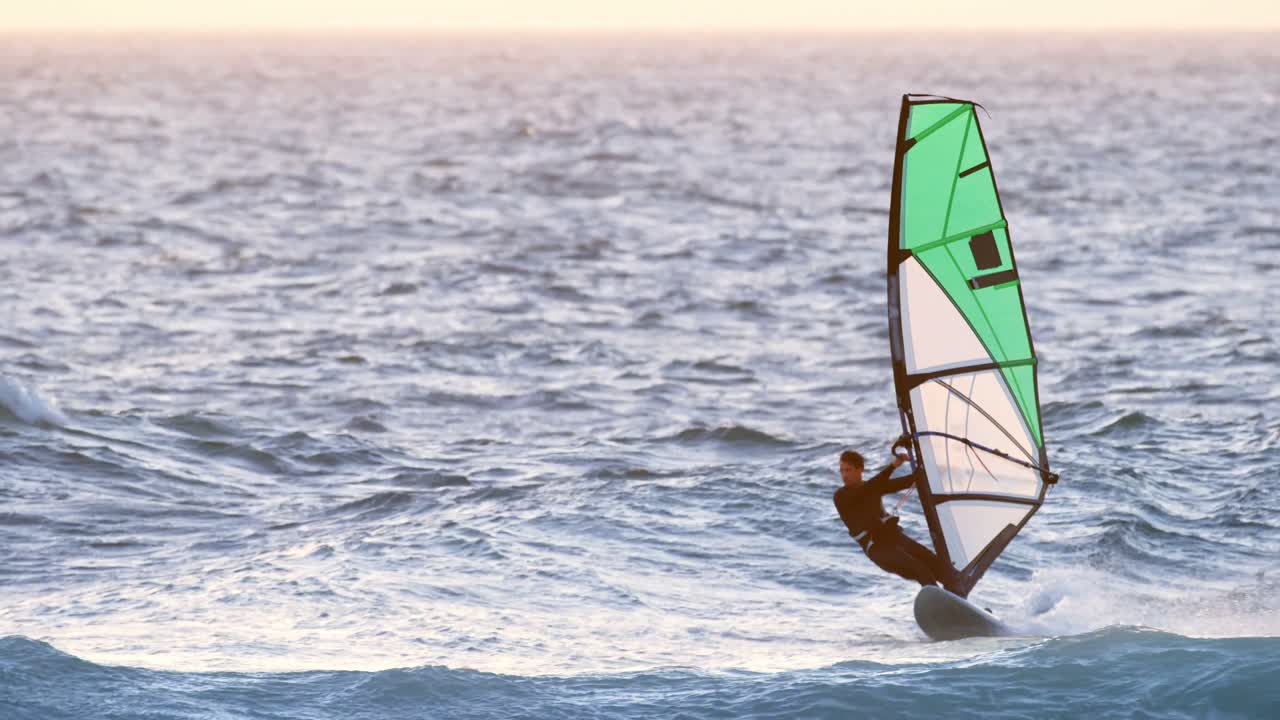 surfista masculino haciendo windsurf en la playa 4k
