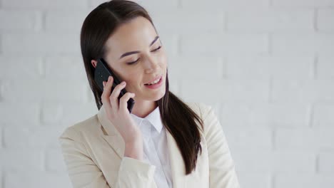 Smiling-businesswoman-speaking-on-teléfono