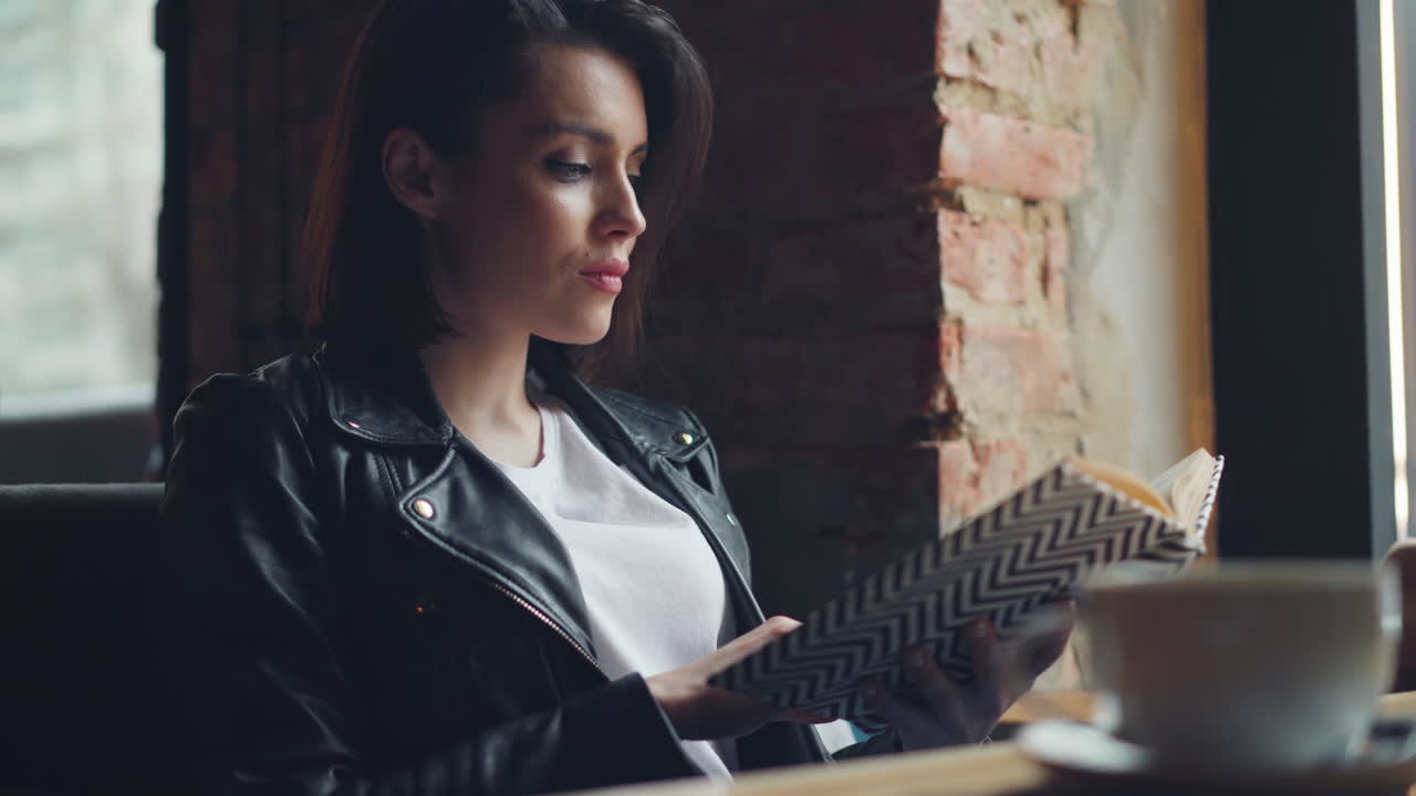 Donna che legge un libro in un caffè