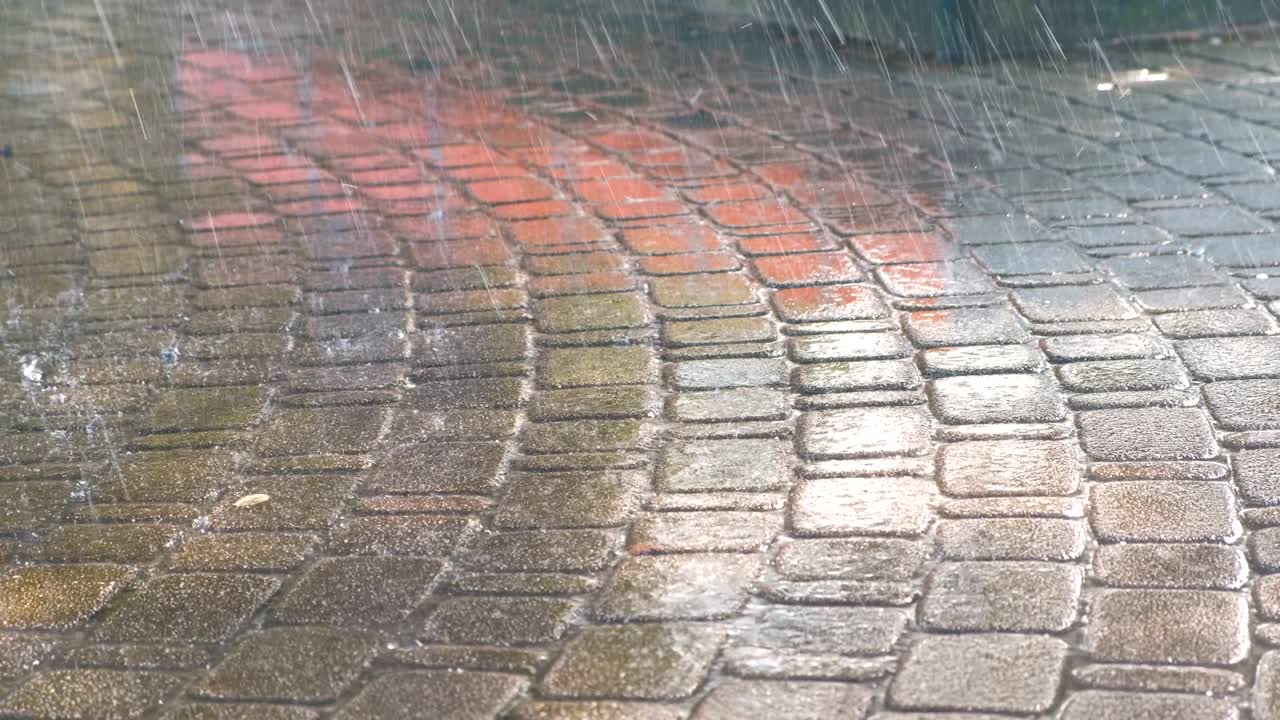 Drops of heavy rain on the pavement.