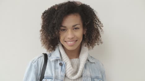 Afro-American-girl-in-casual-clothes-is-looking-at-camera-and-smiling