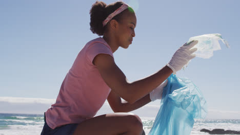 Mujer-Afroamericana-Recogiendo-Residuos-Plásticos-En-La-Playa.