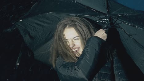 la dama en chaqueta sonríe a la lluvia fuerte en cámara lenta por la noche