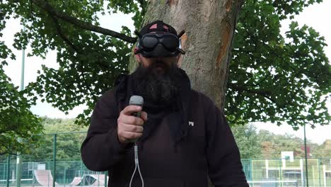 Bärtiger-Mann-Mit-Fpv-brille,-Der-Drohne-Im-Park-Mit-Bewegungsjoystick-Steuert