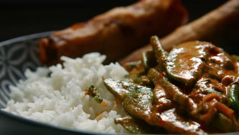 spicy vegan thai red curry with rice and spring rolls