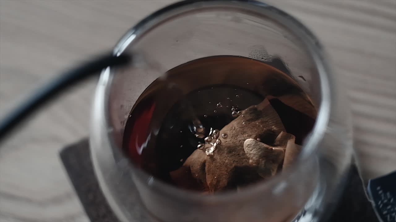 Overhead slow motion shot of hot tea with visible steam rising, capturing the warmth and elegance of the moment. Ideal for food, beverage, wellness, and cinematic lifestyle visuals.