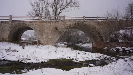 arquitectura bizantina viejo puente sobre el río en un fundamento de invierno con nieve blanca en albania