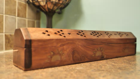 Close-up-of-incense-burning-in-wood-censer