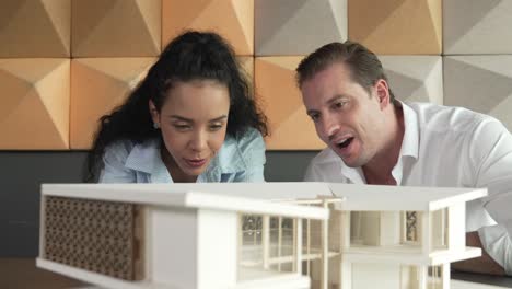 un equipo de arquitectos profesionales discuten sobre la construcción de modelos de casas.