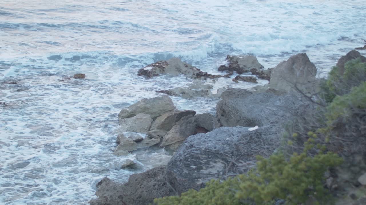 disparo de las mareas del océano golpeando la piedra mantenida en la orilla de una playa