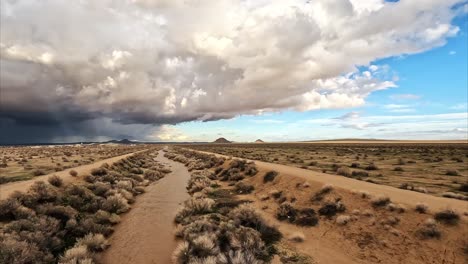 El-Arroyo-Del-Desierto-De-Mojave-Lleno-De-Agua-Mientras-Una-Tormenta-Se-Acumula-En-El-Horizonte---Sobrevuelo-Aéreo