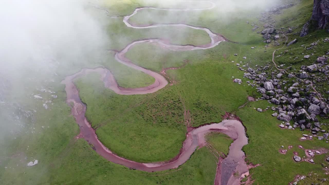 Španělské Pyreneje, Huesca, Španělsko – letecký pohled dronem na údolí Valle de Aguas Tuertas s meandrujícím říčním korytem a pohybujícími se mraky