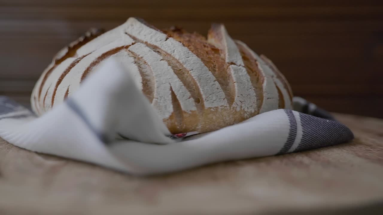 Low angle view of a fancy artisan loaf of bread presented on a spinning wooden table