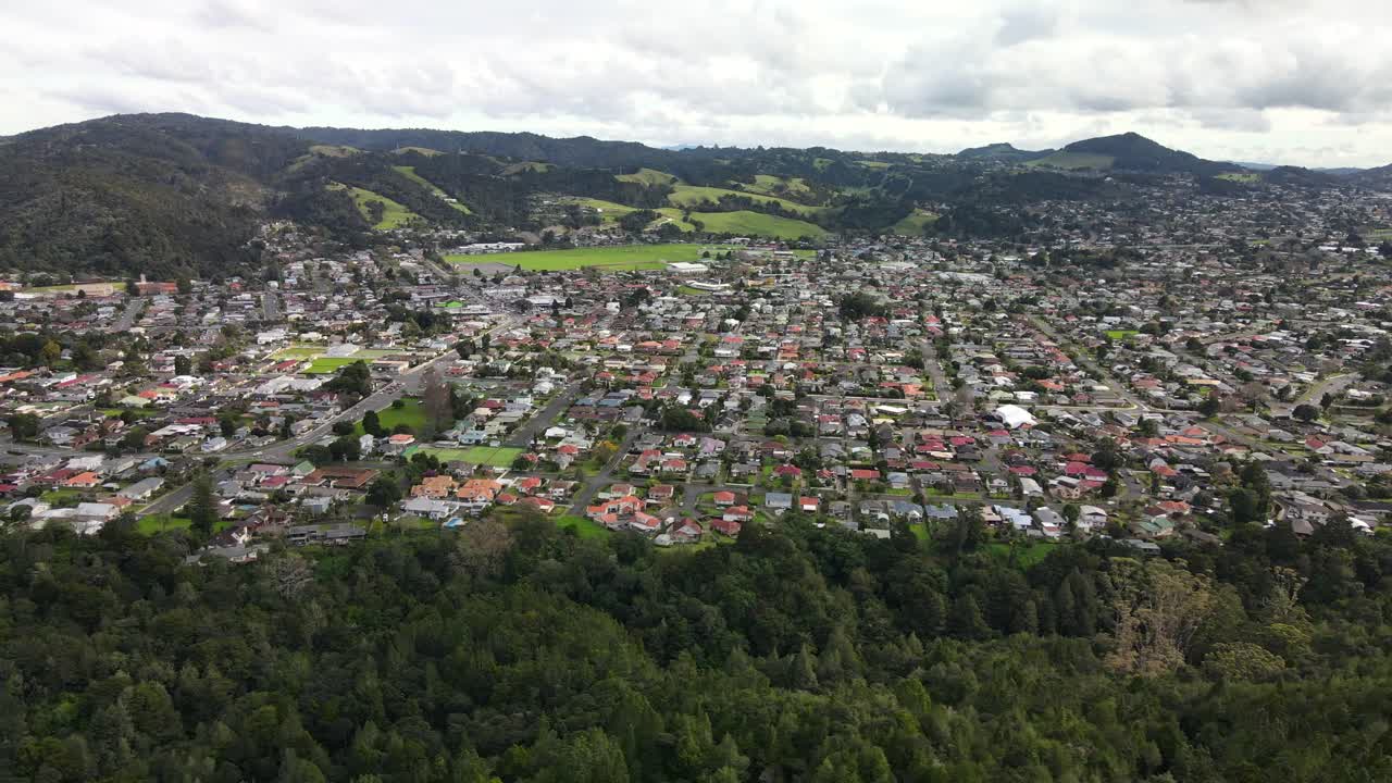 vista aérea de las casas y edificios de la ciudad de whangarei con vistas panorámicas a las montañas en nueva zelanda