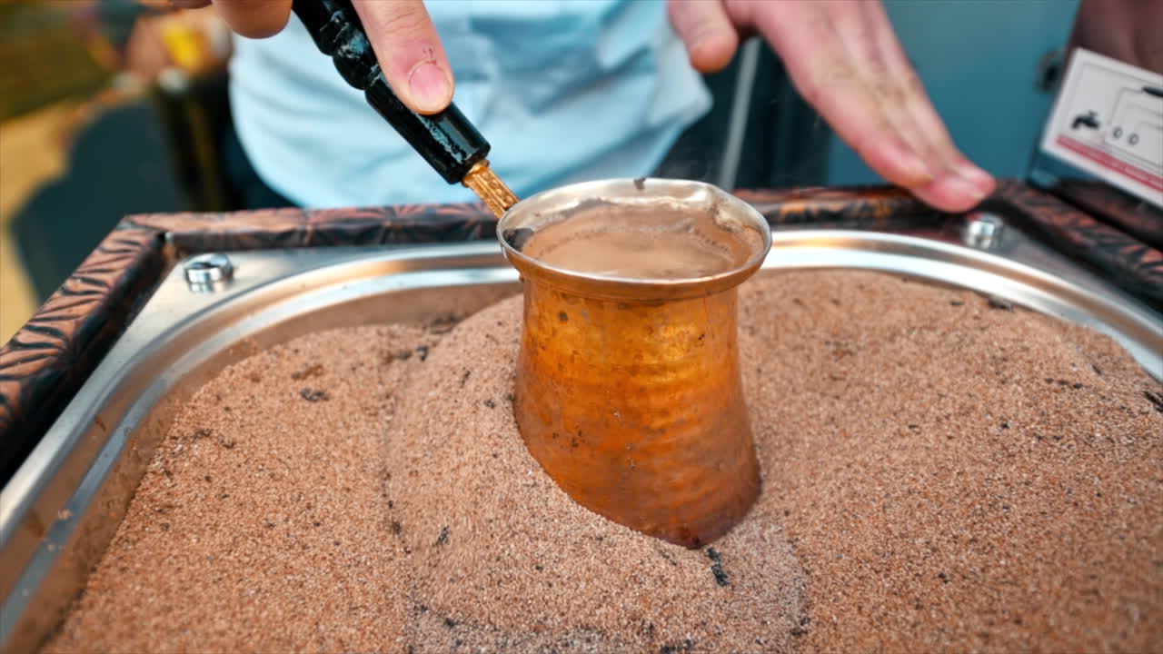 Close view of a barista making coffee on the sand in Istanbul, Turkey. Slow motion
